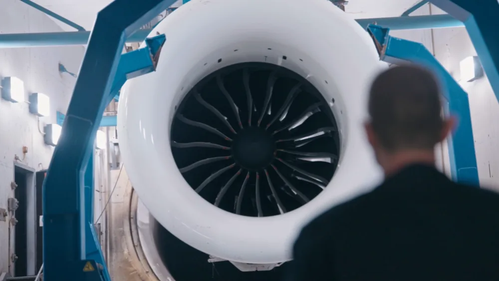 A GE Aerospace employee stands before an aircraft engine at the Prestwick site. (GE Aerospace/PA)