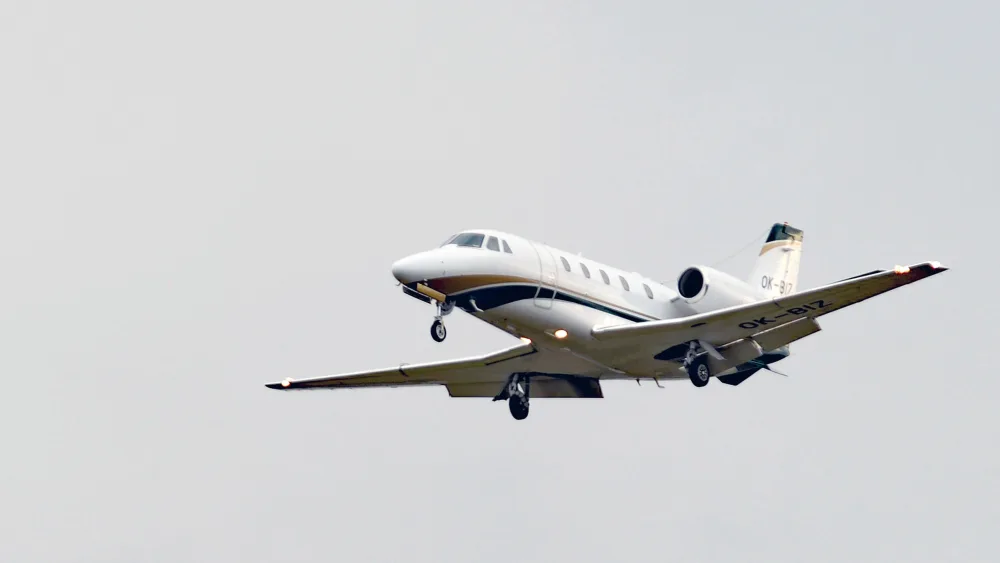 A private jet in the air, with grey skies behind it