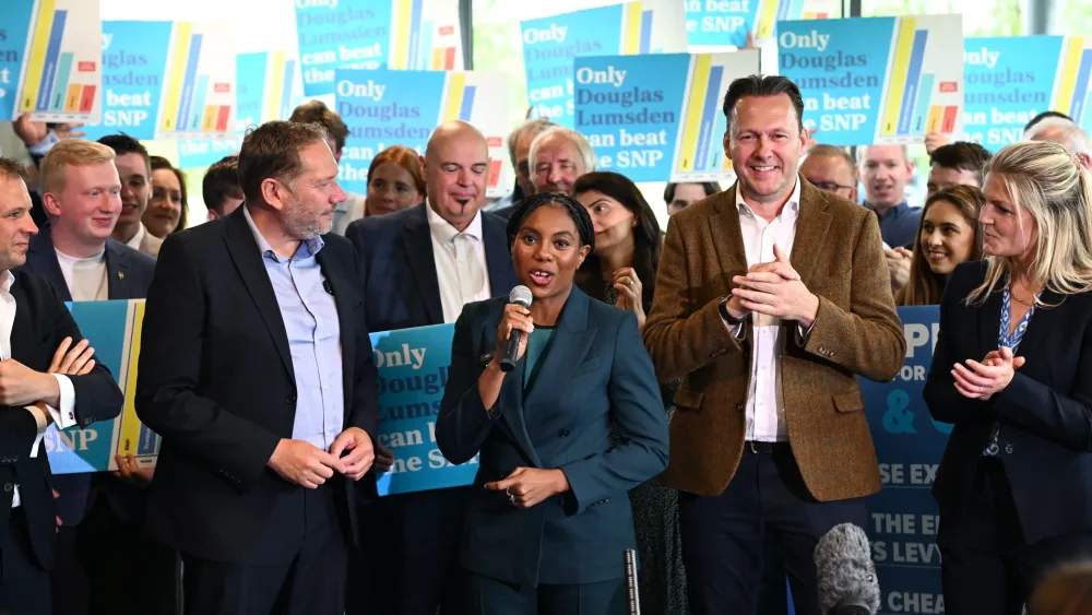 Kemi Badenoch speaking into a mic alongside Douglas Lumden, left, and Russell Findlay