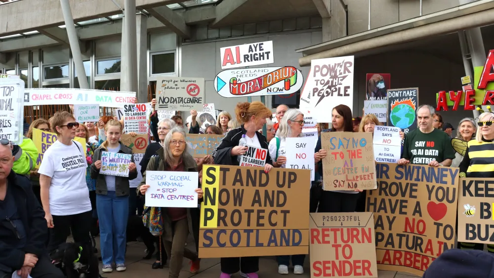 Protesters against data centres holding banners and placards, outside the Scottish Parliament