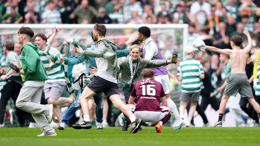Fans invade the pitch at Celtic Park after the home side's third goal