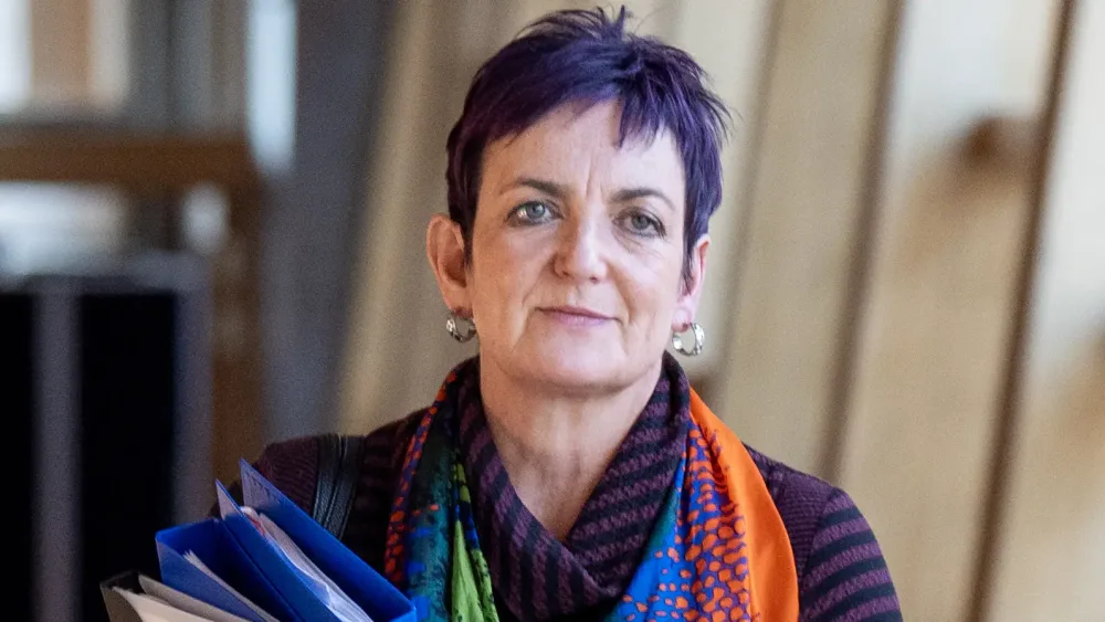 Angela Constance walks down a Scottish Parliament corridor
