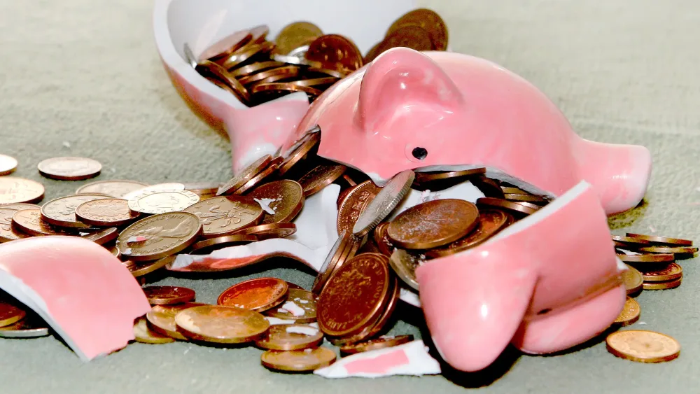 A smashed piggy bank with copper coins inside it