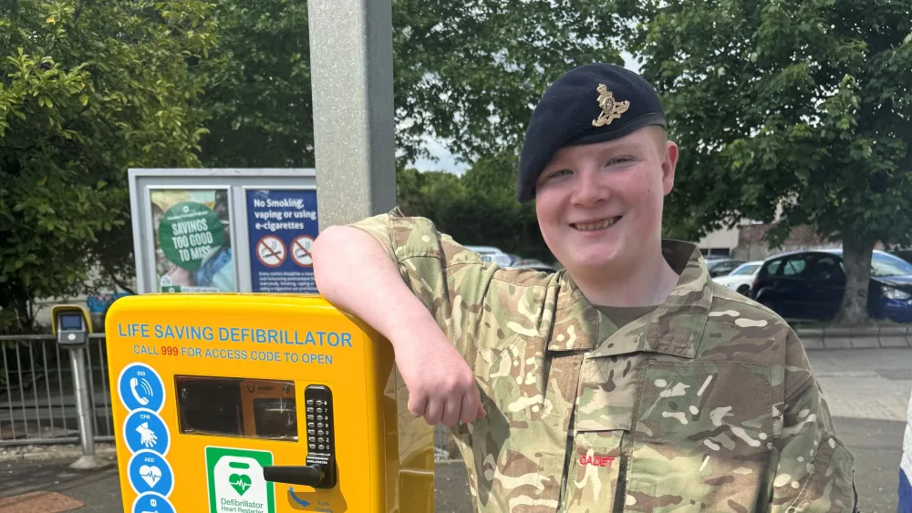Jordan Kerr next to a defibrillator at Drumchapel station