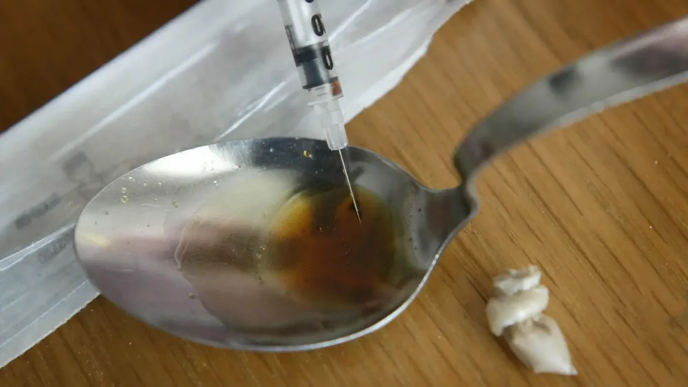 Someone prepares a heroin injection