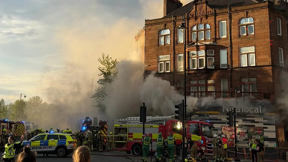 Fire engines and police vehicles outside a building on fire