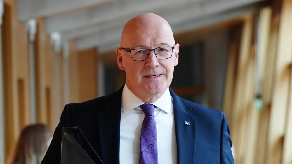 John Swinney walks down a corridor to First Minister’s Questions