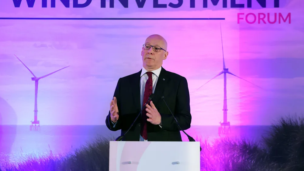 John Swinney speaking from a lectern in front of Global Offshore Wind Investment Forum signage