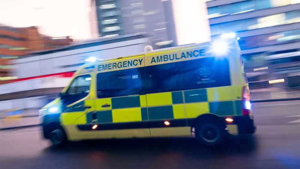 An ambulance travelling at speed, with its blue lights on