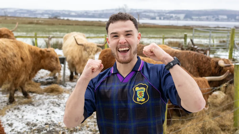 Craig Ferguson in a Scotland shirt in a field with animals