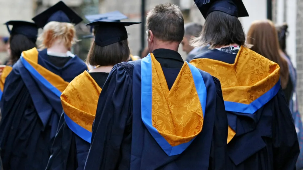 A view of the backs of students in graduation gowns and hats