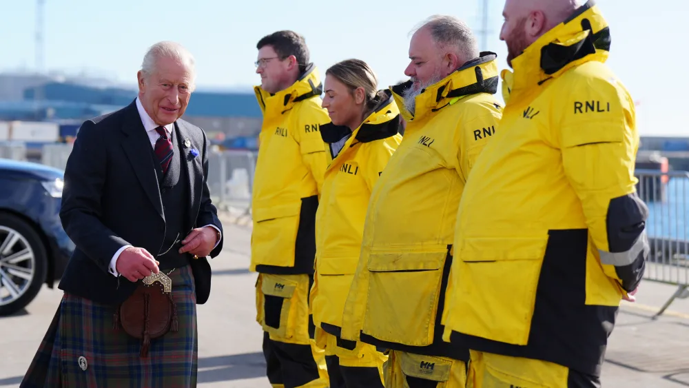The King meeting four RNLI volunteers, who are dressed in yellow