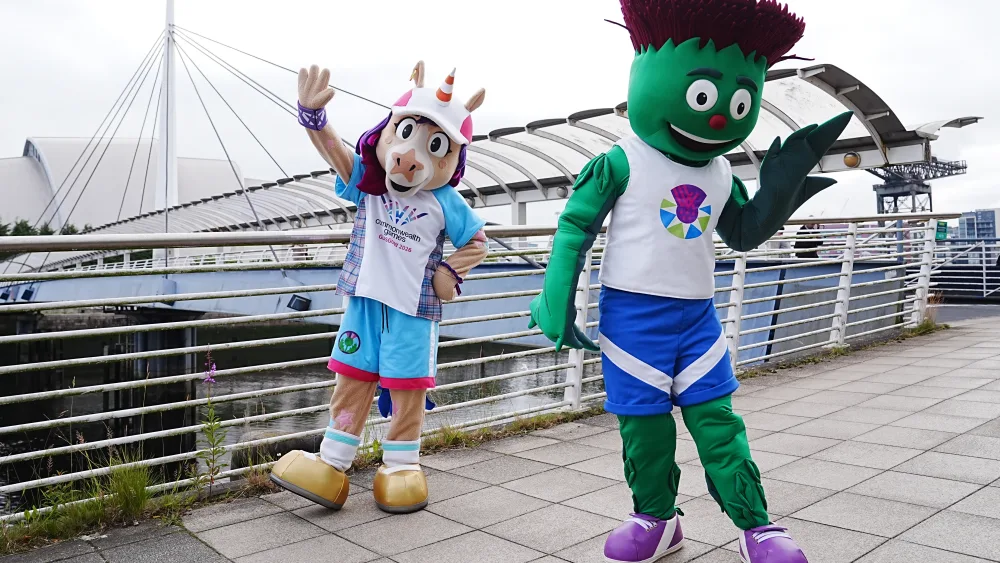 Commonwealth Games mascots Finnie the unicorn and Clyde the thistle posing on a bridge