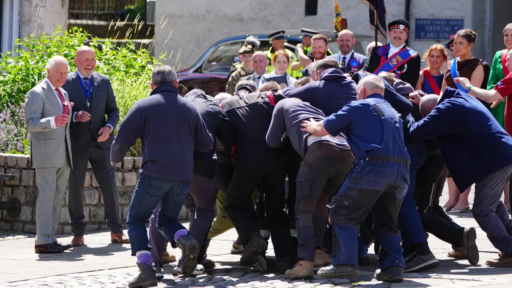 The King watches as a scrum of men fight for a ball