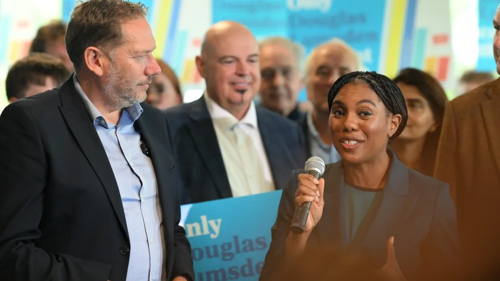 Kemi Badenoch speaking into a mic, alongside Douglas Lumsden and Tory campaigners