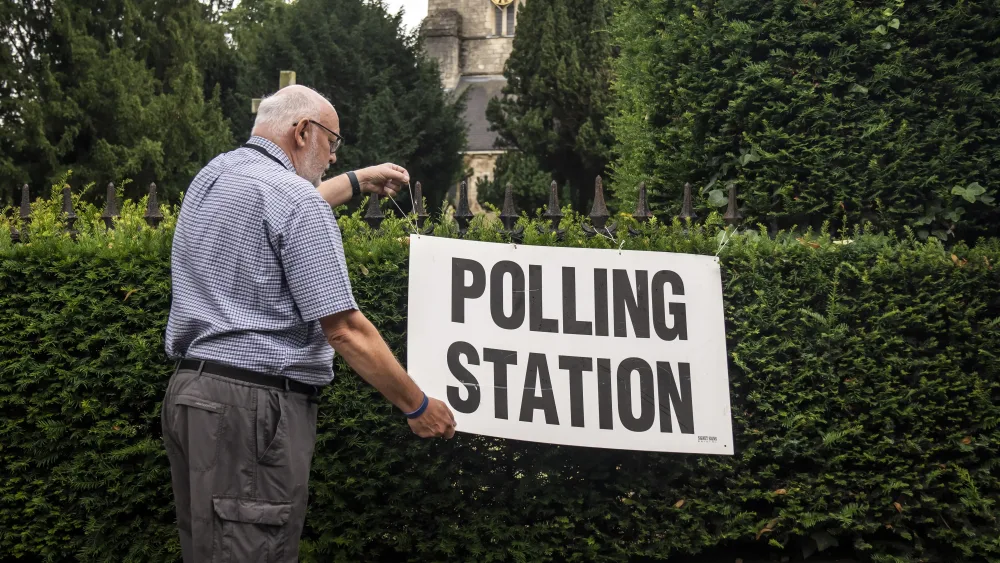 A man adjusts a polling station sign