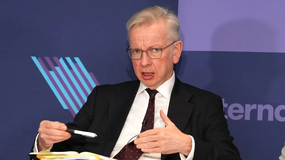 Michael Gove gesturing while speaking, seated as part of a panel