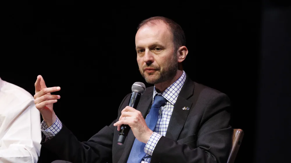 Stephen Gethins gesturing while speaking into a microphone