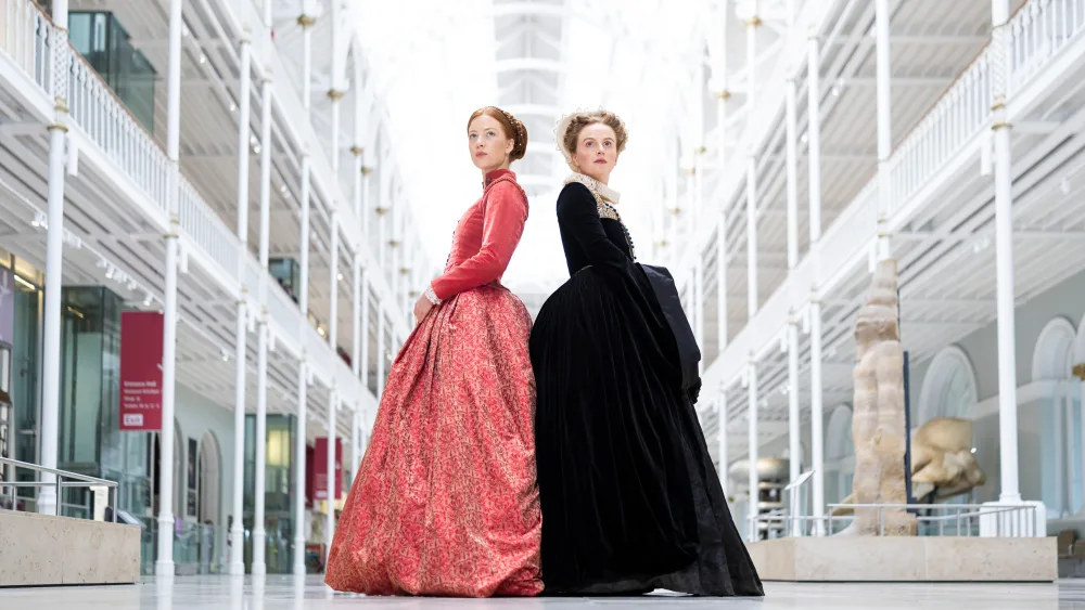 Two models one in a pink dress and one in black