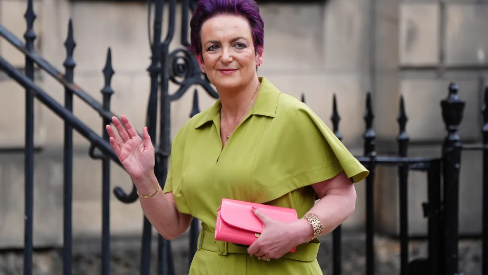 Angela Constance waving while walking outside