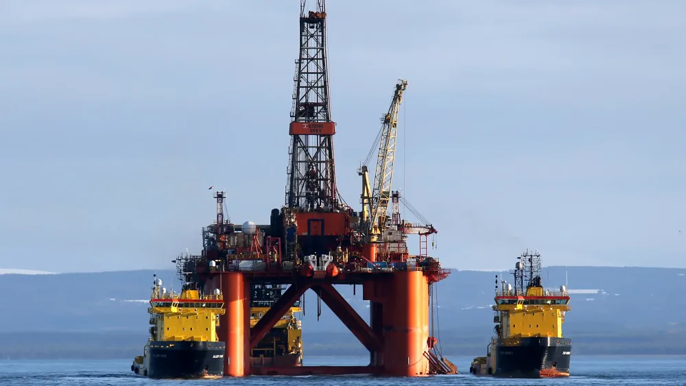 An oil rig next to support vessels