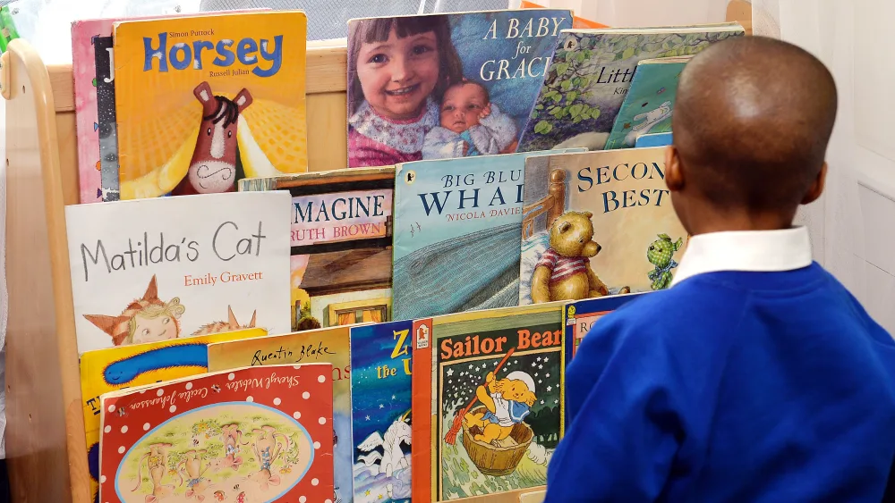 A child looking at books at the Windrush Nursery in Greenwich, south east London