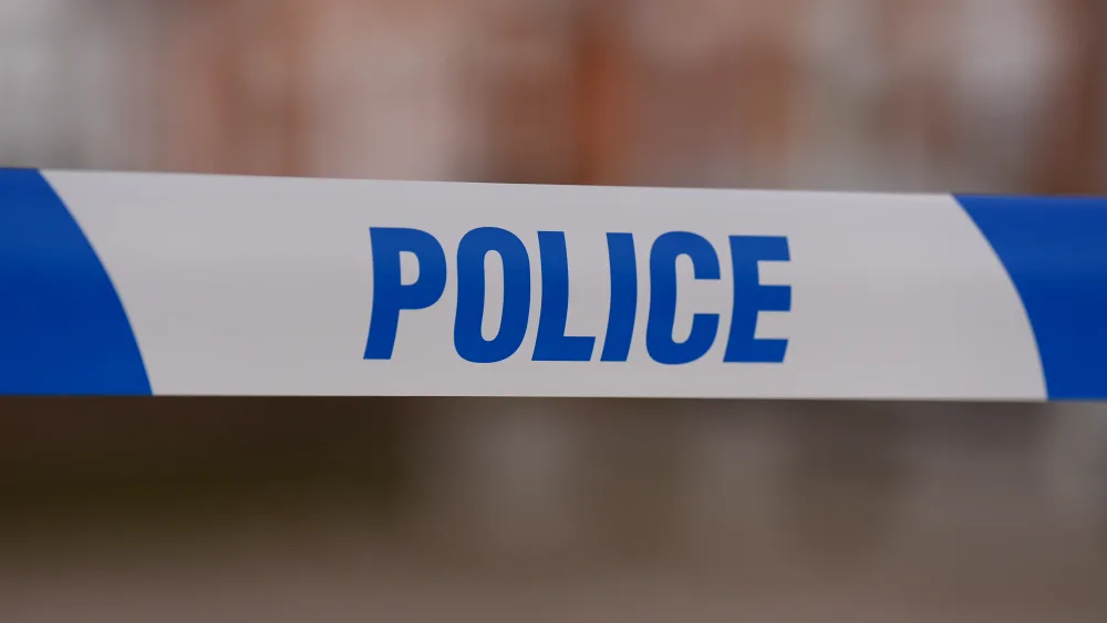 Police tape stretched over a road