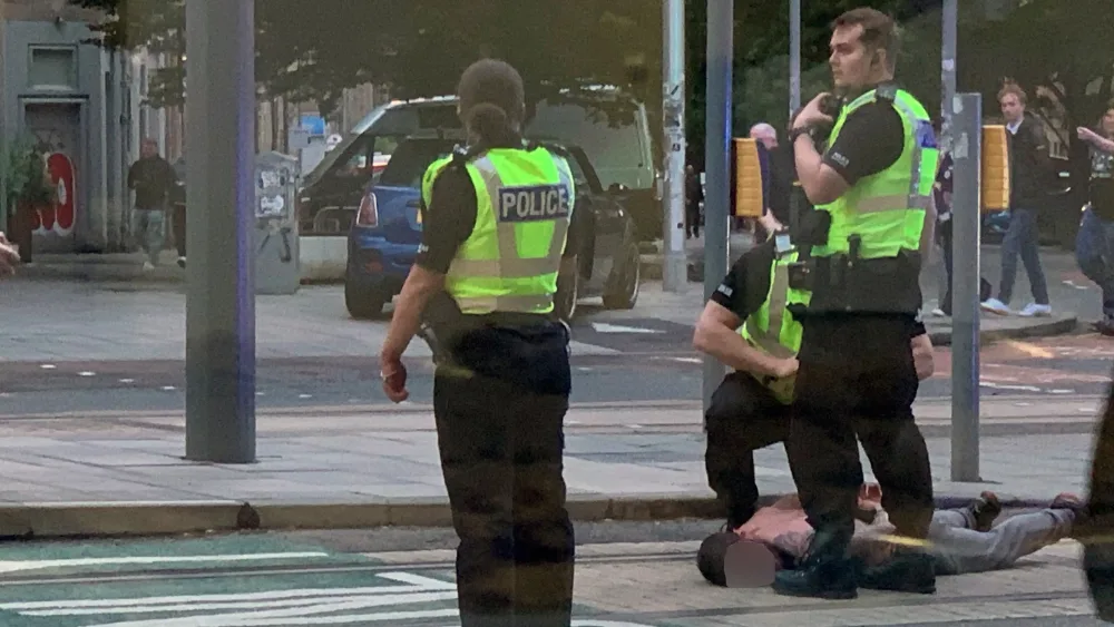A man face down on the street, being arrested