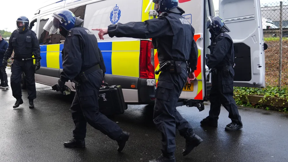 Police officers in protective helmets outside a police van