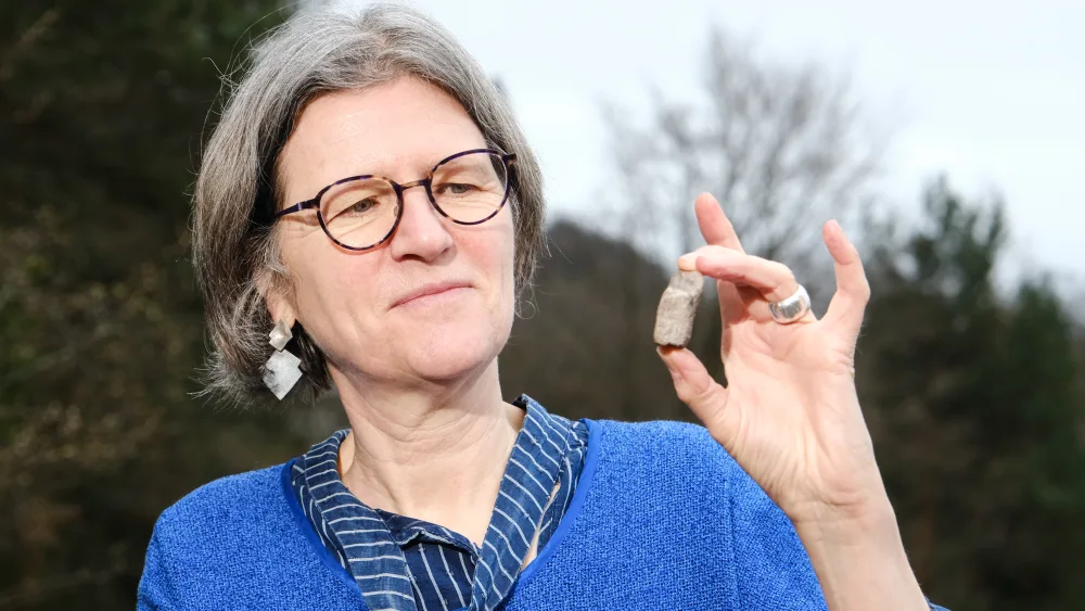 Prof Sally Foster holding up a fragment of the Stone of Destiny