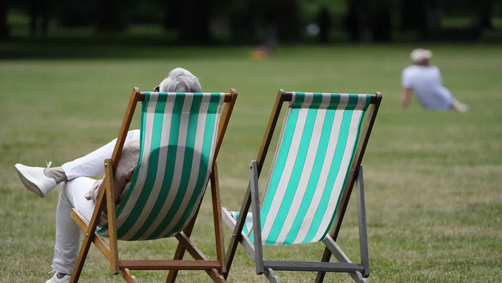 People enjoy the hot weather in Green Park, London on Sunday.