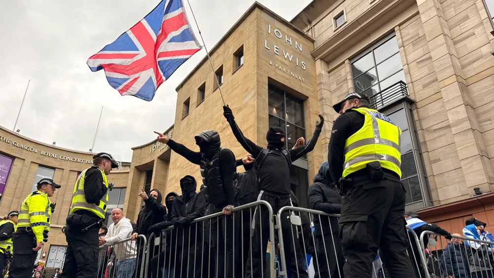 Protesters in black clothing waving a Union flag