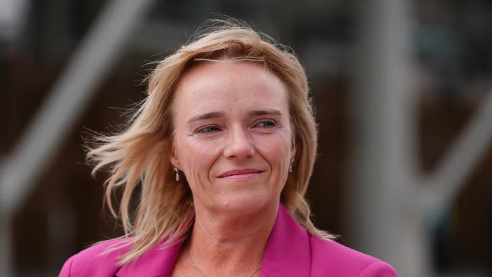 Headshot of Sandie Peggie smiling, wearing a pink blazer