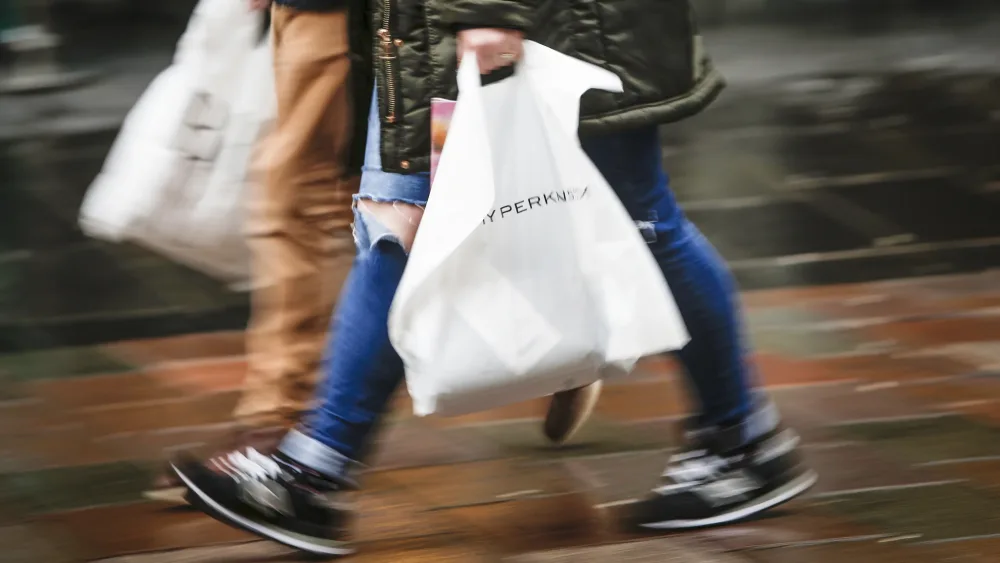 Shoppers with bags walking down a street