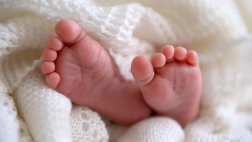 A baby's feet poking out from a shawl