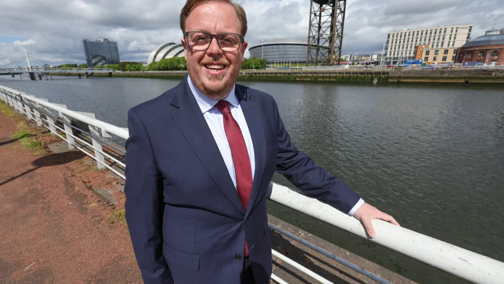 Thomas Kerr stands beside the River Clyde