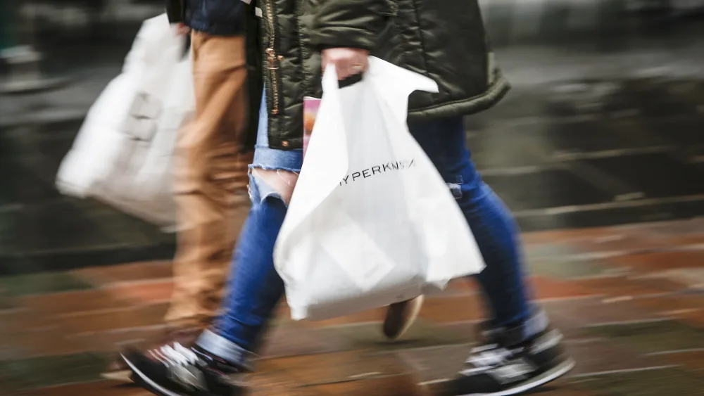 Shoppers walking down a street carrying bags