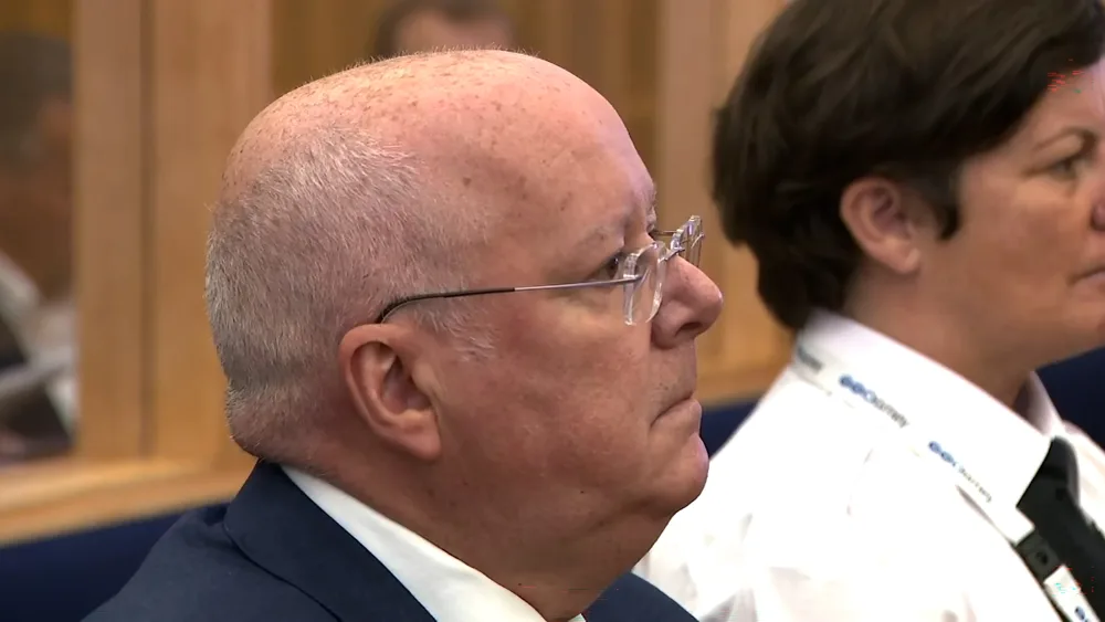 Side view headshot of Peter Murrell in the dock