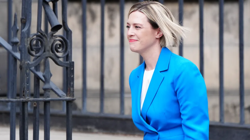 Side view of Jenny Gilruth smiling while walking outside Bute House