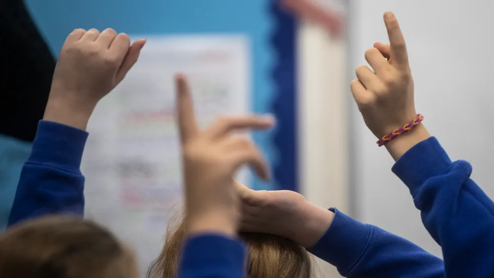 The hands of children as they hold them up in class