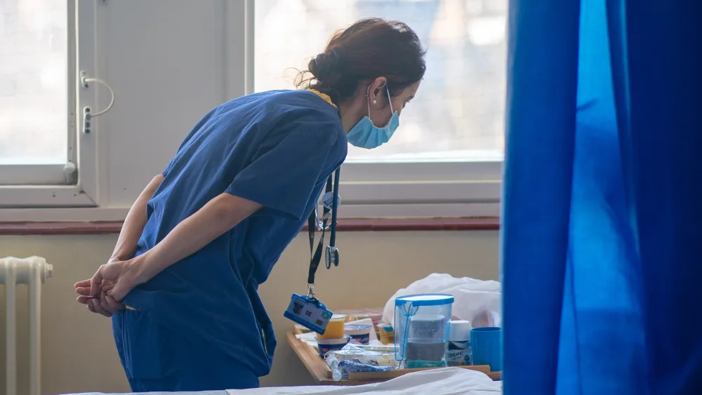 A nurse talking to a patient in a hospital ward