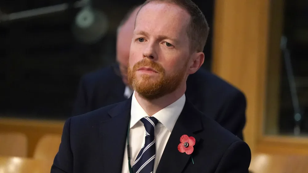 Stephen Boyle seated, wearing a red poppy