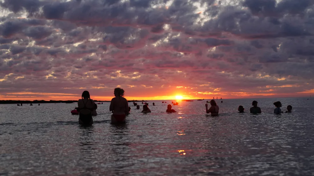 People gather at Cullercoats Bay, North Tyneside during sunrise on the summer solstice, the longest day of the year