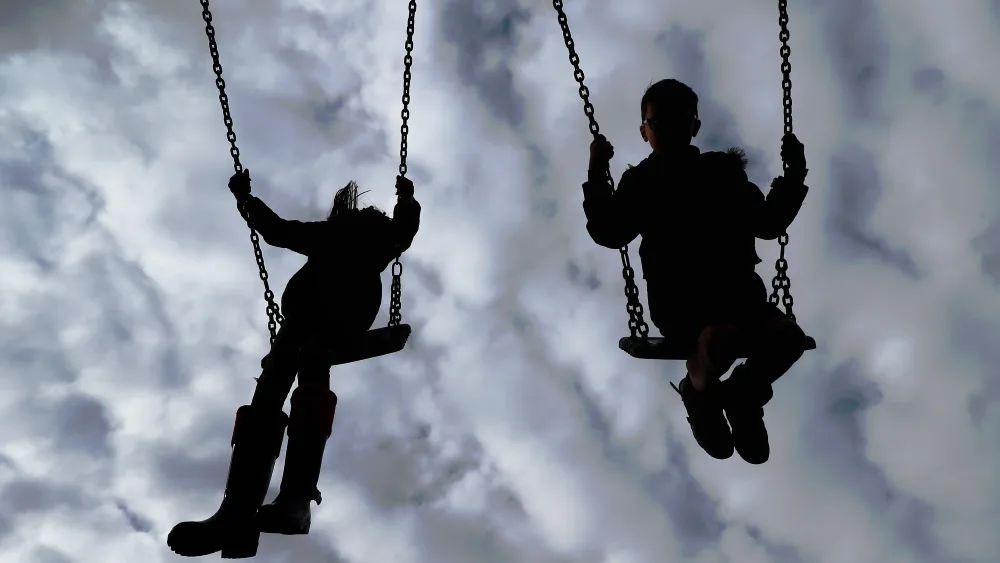 Silhouette of children on swings