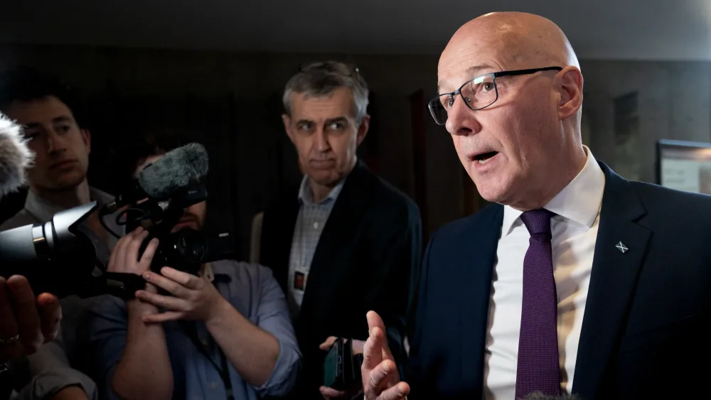 John Swinney talking to journalists