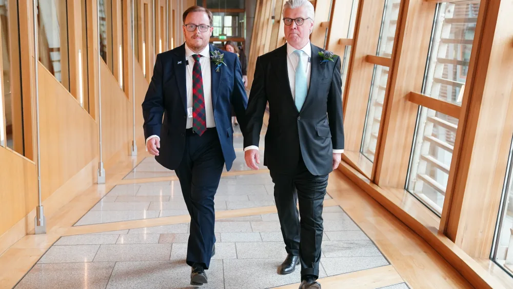 Thomas Kerr and Malcolm Offord walking through at corridor at Holyrood