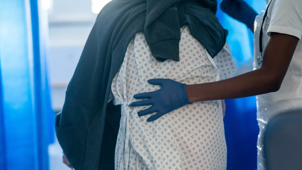 A nurse helps an elderly hospital patient