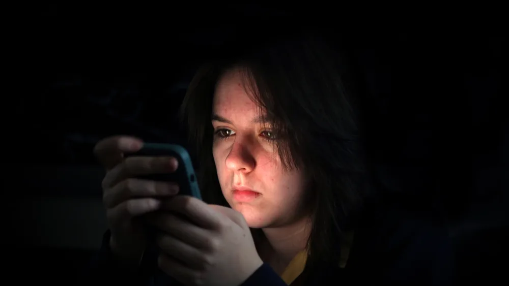 A youngster looking at a phone